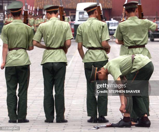 Chinese soldiers adjust their uniforms as they begin marching drills with bayonettes 02 July 1999 in central Beijing. China has been rapidly...