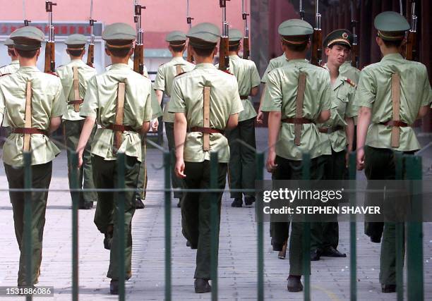 Chinese soldiers, with the aid of small planks and a screaming officer, practice marching drills with bayonettes 02 July 1999 in central Beijing....