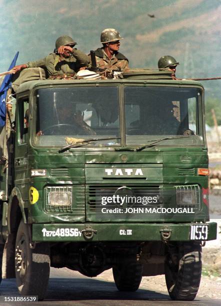 Indian army soldiers are on the lookout as they ride atop a supply vehicle on its way to reinforce the Kargil sector 06 June 1999. India showed signs...