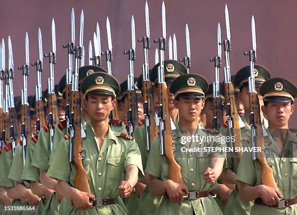 Chinese People's Liberation Army soldiers, some with their eyes closed, march as they practice with their bayonettes during training at their...