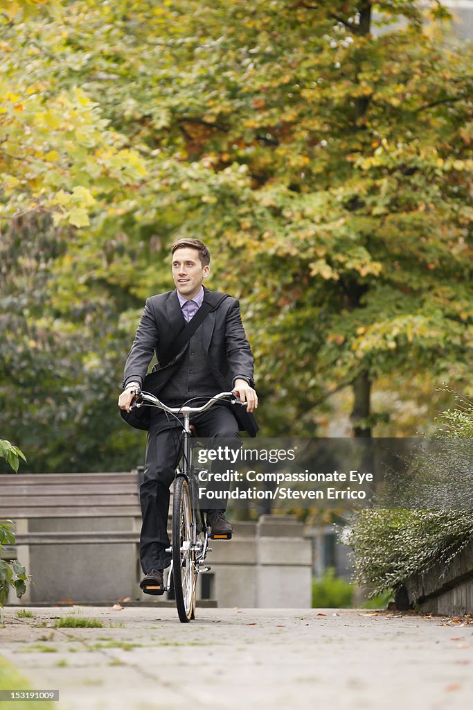 Businessman riding bicycle in park