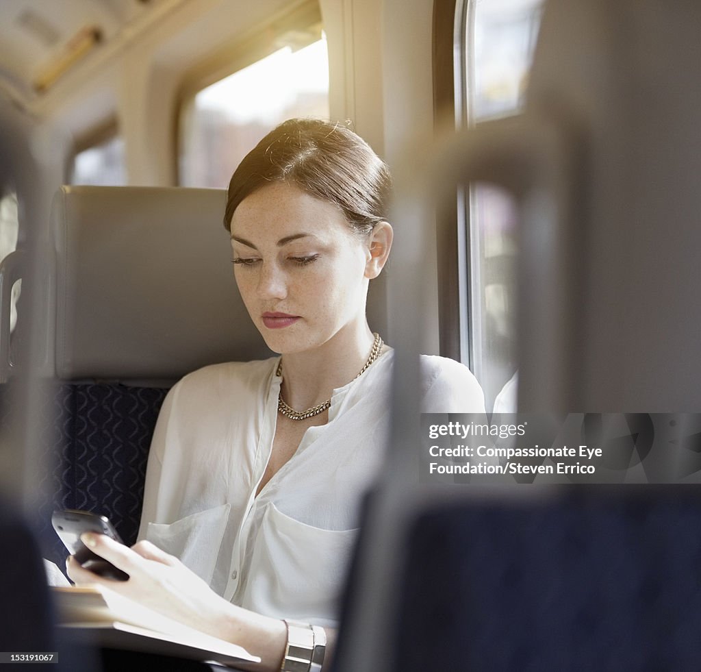Young woman on train using mobile phone