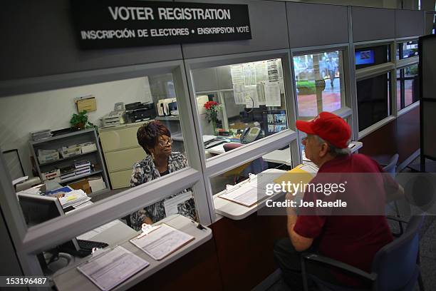 Dorothy Torrence, from the Miami-Dade Elections Department, helps Alvaro Arochena fill out his registration form on October 1, 2012 in Miami,...