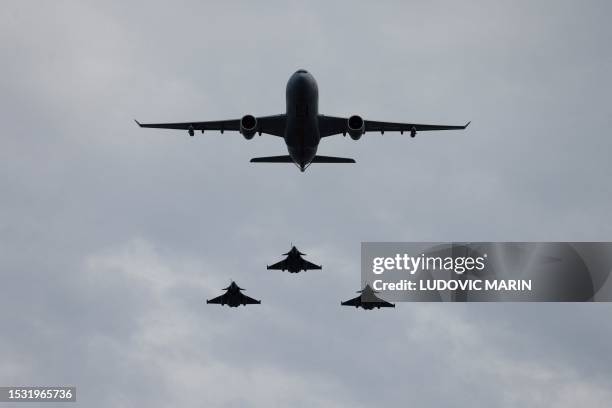 French Air and Space Force Airbus 330 MRTT Phenix and French Air and Space Force Dassault Rafale B multirole fighter aircraft perform a fly-over...