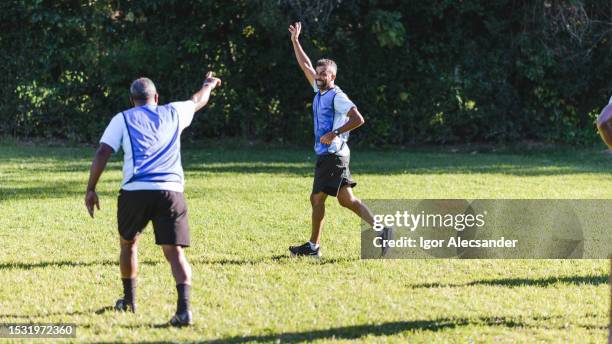 compañeros de equipo celebrando un gol en un partido de fútbol - patrocinador fotografías e imágenes de stock