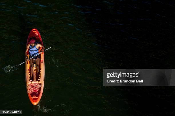 Person kayak's the Colorado River on July 10, 2023 in Austin, Texas. Record-breaking temperatures continue soaring as prolonged heatwaves sweep...