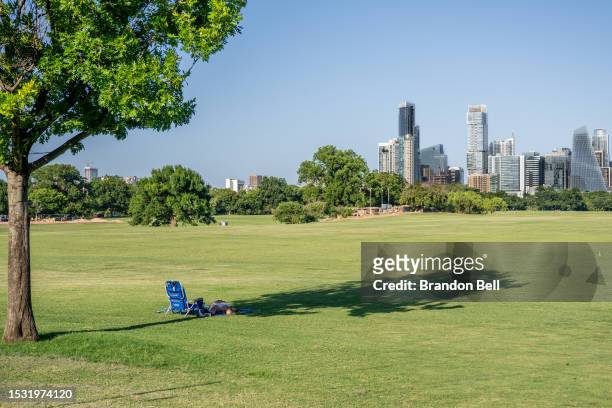 Person rests in the shade at Zilker Metropolitan Park on July 10, 2023 in Austin, Texas. Record-breaking temperatures continue soaring as prolonged...