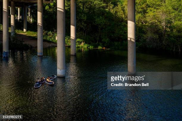 People rest on river boards in the Colorado River on July 10, 2023 in Austin, Texas. Record-breaking temperatures continue soaring as prolonged...