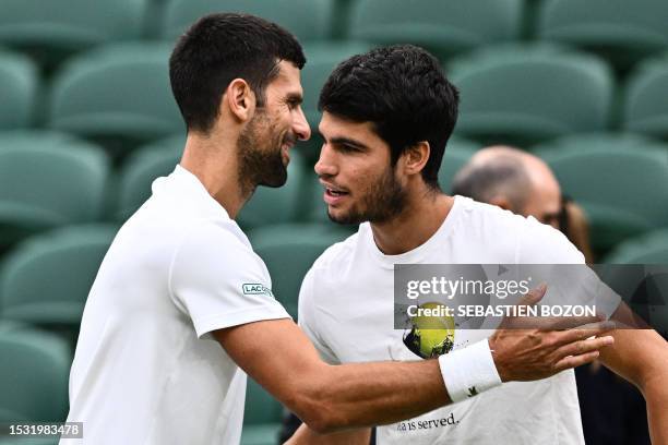 Serbia's Novak Djokovic shakes hands with Spain's Carlos Alcaraz during a practise session prior to their men's singles semi-finals tennis matches on...