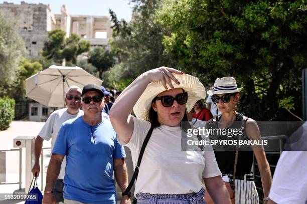 Visitors leave the Acropolis archeological site in Athens on July 14, 2023. The ministry of culture has decided to close the archeological site...
