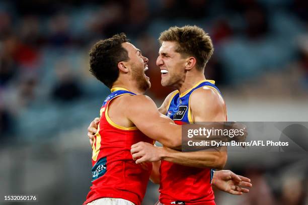 Zac Bailey of the Lions celebrates a goal with teammate Cam Rayner during the 2023 AFL Round 18 match between the Melbourne Demons and the Brisbane...
