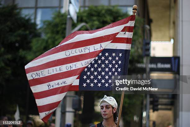 Protester holds an American flag during rally in the downtown financial district to mark the one-year anniversary of the Occupy movement on October...