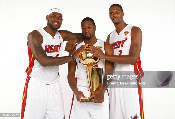 LeBron James, Dwyane Wade and Chris Bosh of the Miami Heat pose for a portrait with the Larry O'Brien trophy during the 2012 Miami Heat Media Day on...