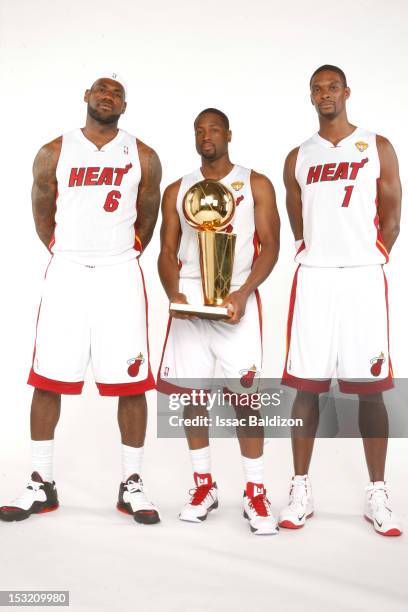 LeBron James, Dwyane Wade and Chris Bosh of the Miami Heat pose for a portrait with the Larry O'Brien trophy during the 2012 Miami Heat Media Day on...