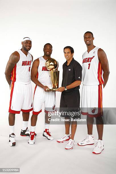 LeBron James, Dwyane Wade, Head Coach Erik Spoelstra and Chris Bosh of the Miami Heat pose for a portrait with the Larry O'Brien trophy during the...