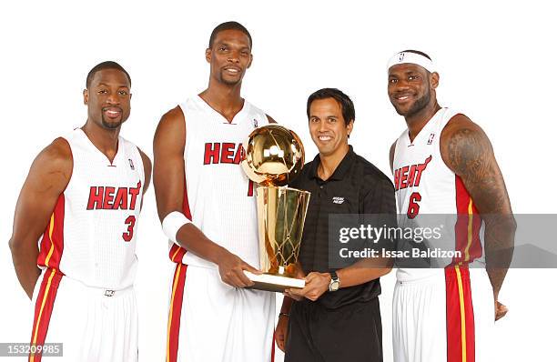 LeBron James, Dwyane Wade, Head Coach Erik Spoelstra and Chris Bosh of the Miami Heat pose for a portrait with the Larry O'Brien trophy during the...