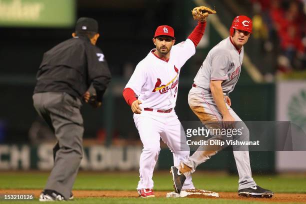 Daniel Descalso of the St. Louis Cardinals and Jay Bruce of the Cincinnati Reds look to the second base umpire for a call at Busch Stadium on October...