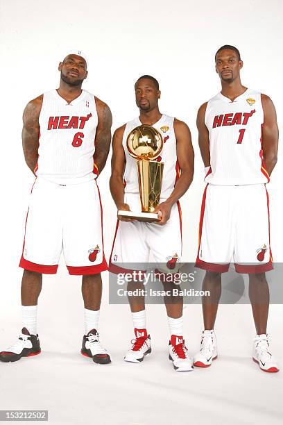 LeBron James, Dwyane Wade and Chris Bosh of the Miami Heat pose for a portrait with the Larry O'Brien trophy during the 2012 Miami Heat Media Day on...