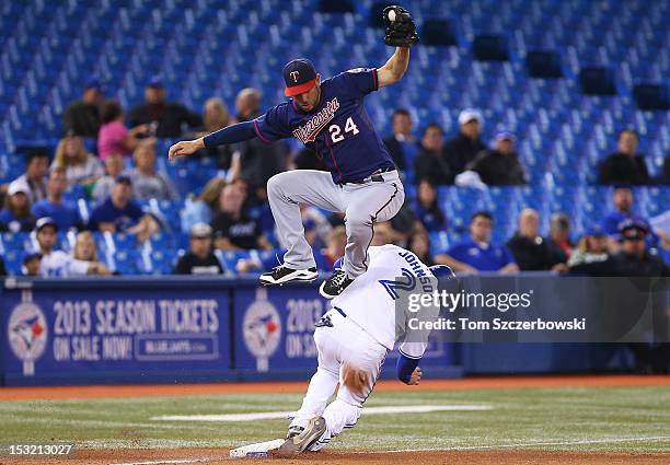 Kelly Johnson of the Toronto Blue Jays steals third base in the eighth inning during MLB game action as Trevor Plouffe of the Minnesota Twins catches...