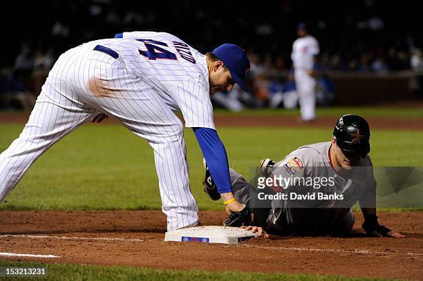 Brandon Barnes of the Houston Astros dives back safely into first base as Anthony Rizzo of the Chicago Cubs makes a tag in the eighth inning on...