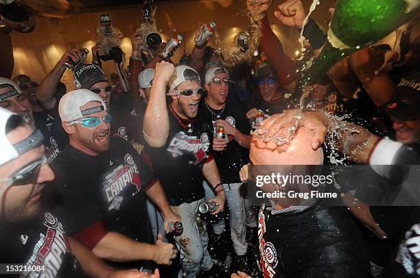 General manager Mike Rizzo is doused with champagne as the Washington Nationals celebrate after winning the National League East Division...