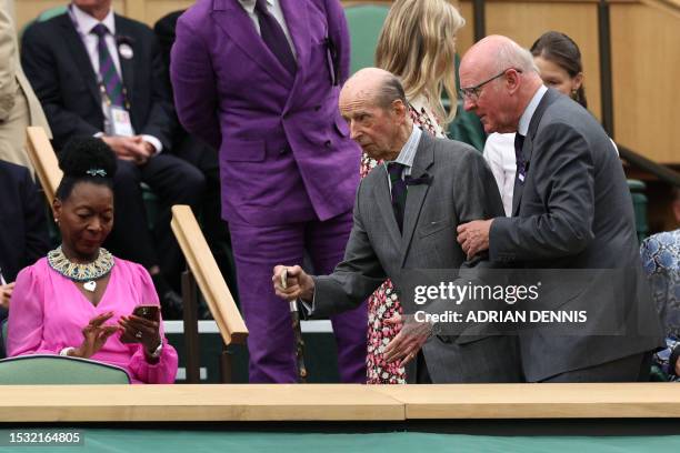 Britain's Prince Edward, Duke of Kent and Chairman of AELTC Ian Hewitt arrive as Floella Karen Yunies Benjamin, Baroness Benjamin, checks her mobile...