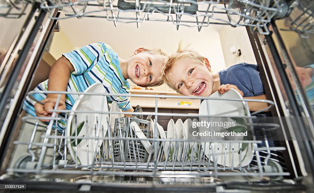 Two boys unloading a dishwasher