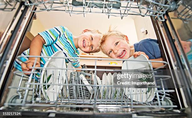 two boys unloading a dishwasher - small dishwasher stock pictures, royalty-free photos & images