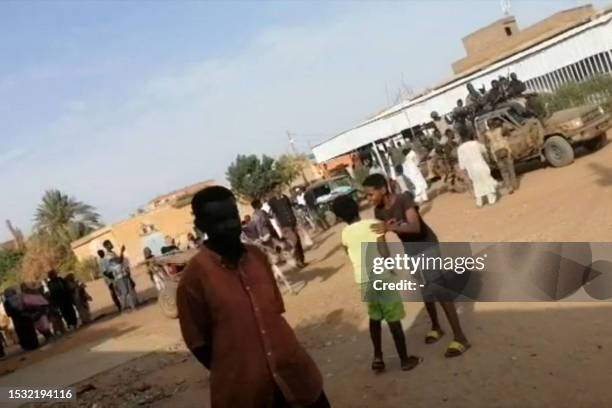 This frame grab taken from AFPTV video footage shows Sudanese armed forces driving military vehicles through a street in Omdurman on July 13, 2023.