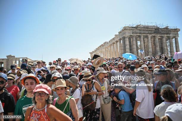 July 2023, Greece, Athen: A large crowd of tourists visit the Parthenon Temple on the Acropolis Hill on this hot day. The Ministry of Culture has...