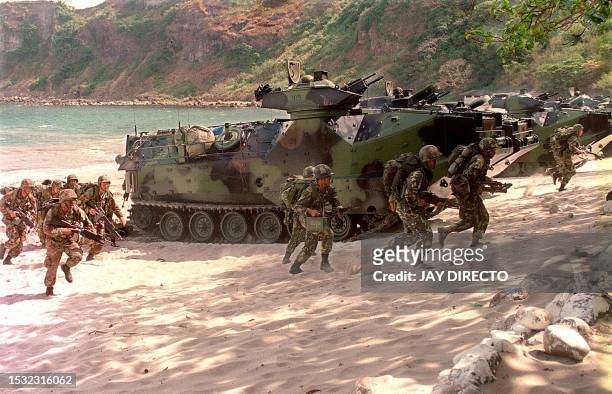 And Philippine marines participate in an amphibious assault landing exercise 28 February 2000 at a marine reserve south of Manila as part of ongoing...