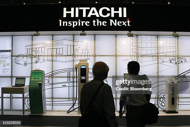 Attendees look at a display in the Hitachi Ltd. Booth at the CEATEC Japan 2012 exhibition in Chiba, Japan, on Tuesday, Oct. 2, 2012. The trade show...