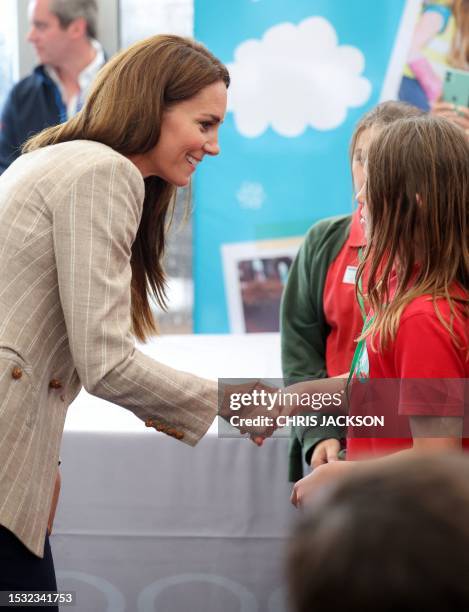 Britain's Catherine, Princess of Wales shakes hands and speaks with winners of the Road to RIAT national schools competition in the Techno Zone,...