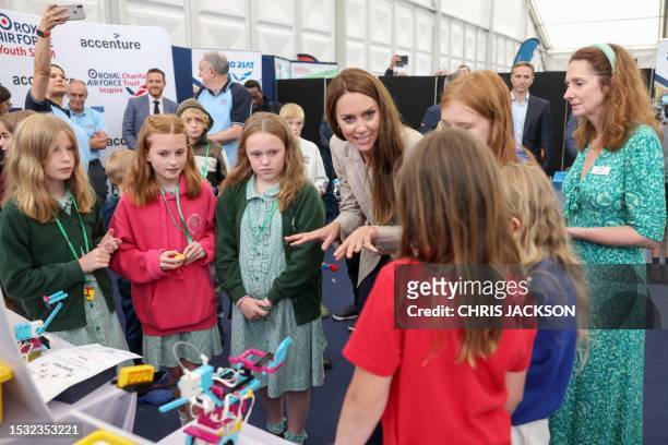Britain's Catherine, Princess of Wales speaks with winners of the Road to RIAT national schools competition at the Techno Zone, which aims to inspire...