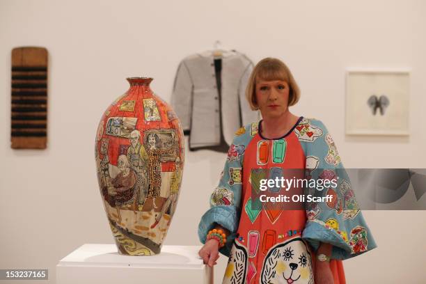 Artist Grayson Perry poses next to his vase entitled 'Bad Portraits of Establishment Figures' in the 'RA Now' exhibition at the Royal Academy on...