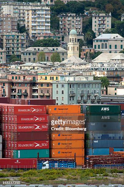Shipping containers, operated by Hapag-Lloyd and Hamburg Sud, sit stacked in front of residential apartments, at Genoa port in Genoa, Italy, on...
