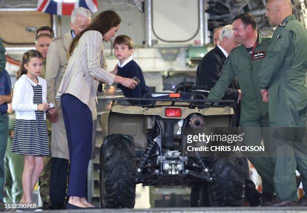 Britain's Catherine, Princess of Wales speaks with Britain's Prince Louis of Wales as he sits inside a vehicle on a C17 plane during a visit to the...