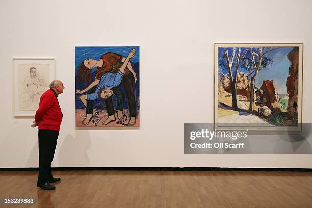 Man admires the artworks on display in the 'RA Now' exhibition at the Royal Academy of Arts including a painting by Eileen Cooper entitled 'Real...