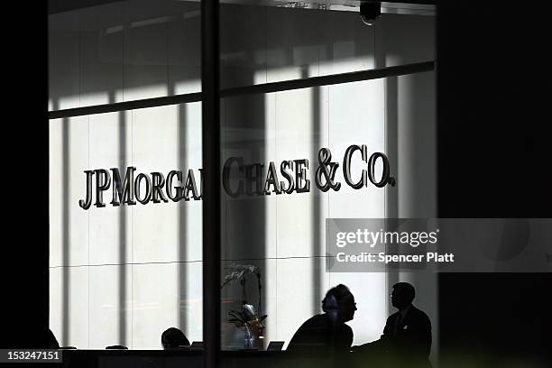 People pass a sign for JPMorgan Chase & Co. At it's headquarters in Manhattan on October 2, 2012 in New York City. New York Attorney General Eric...