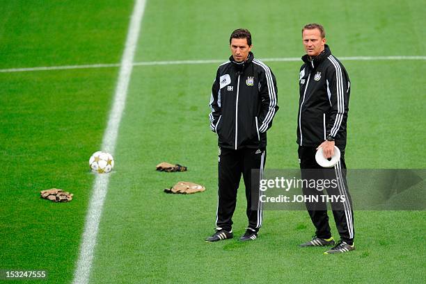 Anderlecht's head coach John van den Brom speaks with Anderlecht's assistant coach Besnik Hasi during a training session on the eve of the Champions...