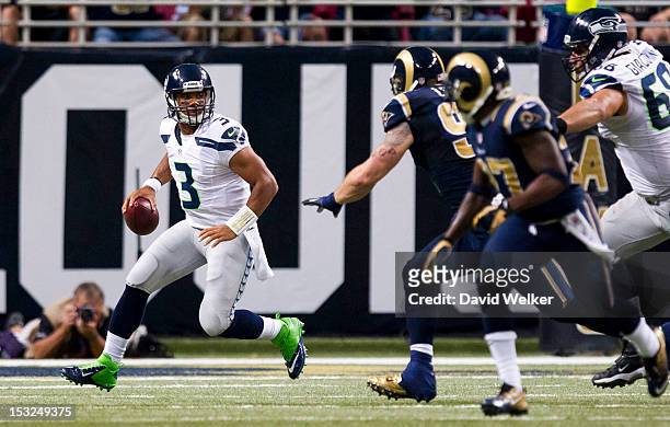 Quarterback Russell Wilson of the Seattle Seahawks attempts to avoid pressure from the St. Louis Rams defense during the game at the Edward Jones...