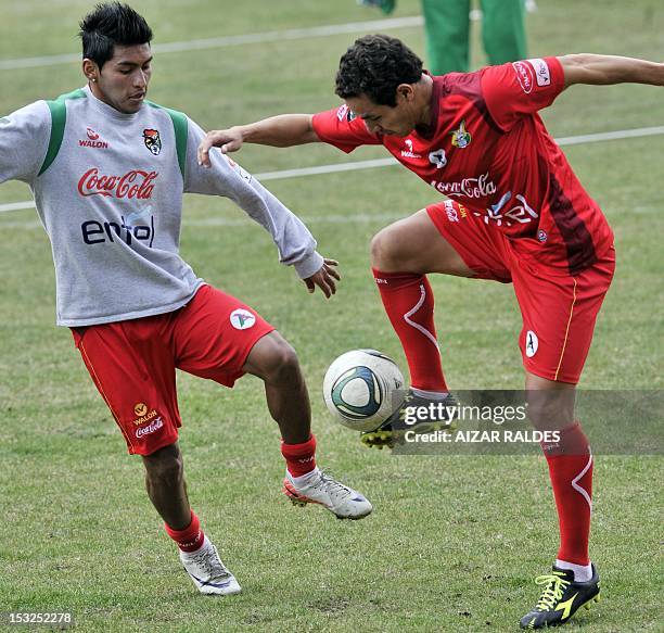 Bolivian players Ruddy Cardozo and Walberto Mojica vie for the ball during a training in La Paz on October 2, 2012. Bolivia will face Peru on October...