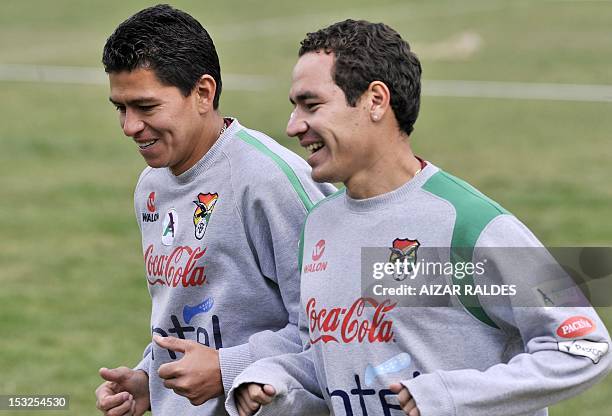 Bolivian players Carlos Saucedo and Walberto Mojica jog during a training in La Paz on October 2, 2012. Bolivia will face Peru on October 12, in a...