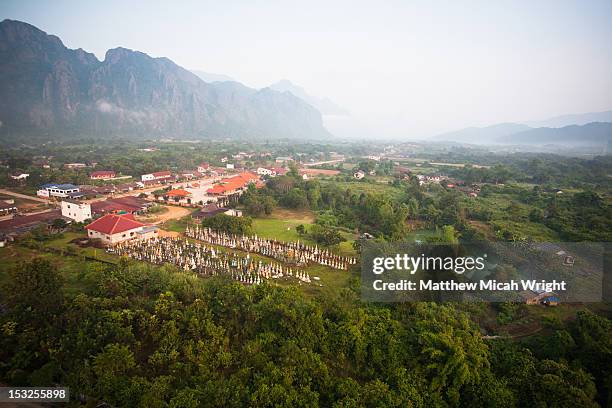 aerial views over a graveyard in a city. - vang vieng balloon stock pictures, royalty-free photos & images