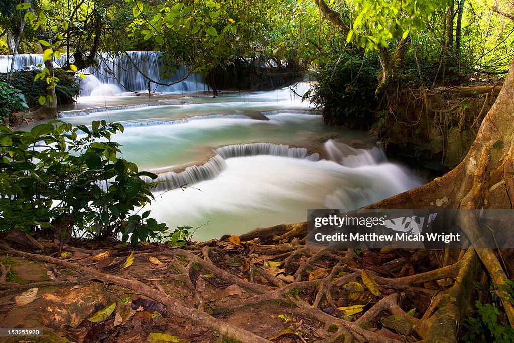 A waterfall running into an emerald pond.