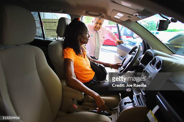 Chrysler sales consultant Marco Bernal shows a Jeep Compass to Veronica Walker at the Hollywood Chrysler Jeep car dealership on October 2, 2012 in...