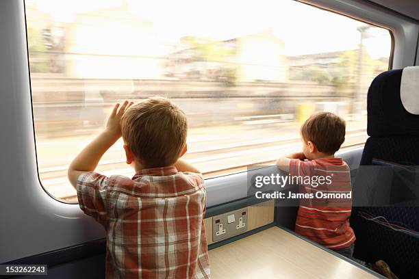 children on a train looking out of the window - tåginteriör bildbanksfoton och bilder