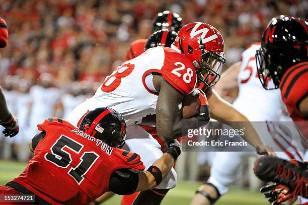 Running back Montee Ball of the Wisconsin Badgers powers through linebacker Will Compton of the Nebraska Cornhuskers during their game at Memorial...