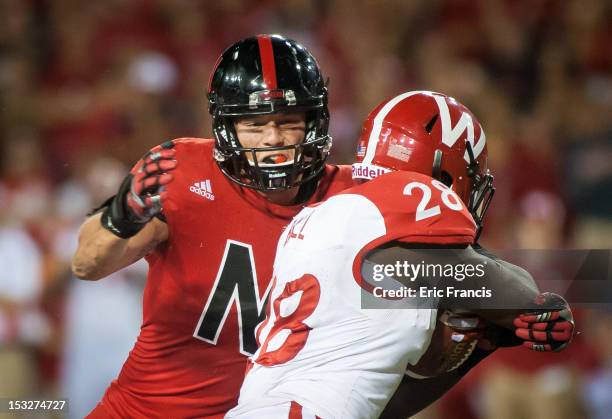 Defensive tackle Baker Steinkuhler of the Nebraska Cornhuskers zeros in on running back Montee Ball of the Wisconsin Badgers during their game at...