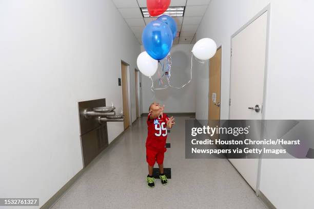 Ronald Reynolds plays with balloons after leading the Pledge of Allegiance to the Flag at the grand opening of a Democratic National Committee...